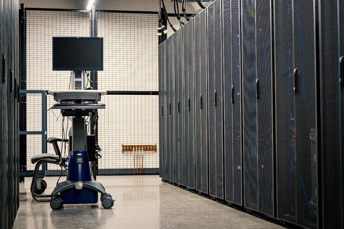 A mobile console workstation in front of a data center server rack aisle